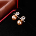 Detailaufnahme luxuriöser Perlenohrringe mit Zirkon in roter Schmuckschatulle mit Samt - Gold Perle Zirkonia Stil