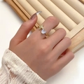 Elegant gold bow ring with heart zircon stone worn by woman with lace cuff - Gold Heart Flower Open Ring (4524)