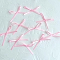 Set of 9 small pink satin ribbon bows for cake decoration on white textured surface - Pink Bow Small