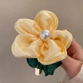 Handheld view of a yellow organza flower hair scrunchie with a large white pearl center - Yellow Flower Large Scrunchie