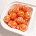 Close-up of glossy orange acrylic pearlescent round beads for DIY jewelry making - Orange