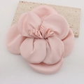 Vista detallada de un broche de rosa de tela rosa hecho a mano sobre piedra decorativa - Rosa