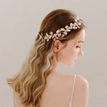 Bridal hair comb with gold metal leaves, white flowers and pearls worn by a model - 2# Rose Gold Hair Vine