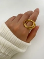 Dettaglio di un anello a doppio cerchio intrecciato placcato in oro sulla modella - Oro / Numero 7