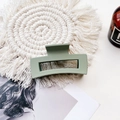 Detail view of a pale green matte rectangular hair claw clip on a woven mat background - Medium Matte Square - Light Army Green