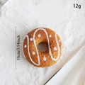 Detalle de un adorno navideño de dónut marrón con medidas de 10cm y un peso total de 12g - Dona