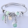 Silver twisted wire bracelet with green crystal beads and a handmade palm pendant - Green