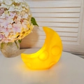 Cute yellow moon-shaped LED night light emitting warm glow on a minimalist white desk - Large Cheese Moon - Yellow
