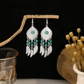 Detail of silver feather tassel earrings with turquoise beads on a wooden stand - Artificial Turquoise Feather Pendant Style (E3825)