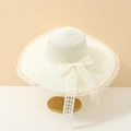 Detail of wide brim straw hat with elegant lace bow and floral ribbon on a gold stand - Adult 55-58cm / Cream