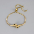 Luxurious gold-tone double snake head bolo bracelet with sparkling white crystal pavé - Gold with Black Eyes