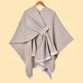 Chic beige knitted poncho with cross-wrap strap design and white tassel hem details - Speckled with White Fringe / Khaki
