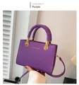 Détail d'un sac violet en cuir grainé avec poignées tressées et finitions dorées chic - Violet