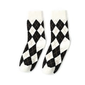 Klassische schwarz-weiße Argyle-Stricksocken mit orangefarbenen Akzenten auf weißem Hintergrund - Einheitsgröße / Schwarz-Weiß Argyle