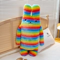 Regenbogen gestreifte langohrige Hasen-Plüschpuppe lehnt an einem hölzernen Kopfteil - Bunt / 50cm