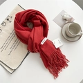 Soft red cashmere-feel scarf with elegant tassels displayed on a cozy table setting - Sunset Red