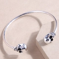 Gothic style double skull open cuff bracelet in silver finish on display stand - Silver
