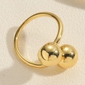 Detailed macro view of a gold bypass ring featuring dual polished spherical metal ends - Gold Double Ball Bypass Ring