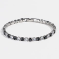 Close-up of 4mm tennis bracelet with clear zircons and black evil eye square charms - Black White Gold