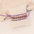 Bohemian purple woven beaded bracelet set with gold beads on display pillow - Purple