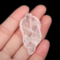 Hand holding a leaf-shaped translucent natural crystal stone pendant with internal veins - White Crystal