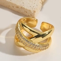 Makro-Detail eines goldenen mehrschichtigen Rings mit Zirkonia-Mikropavé-Besatz - Wickeldesign