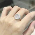 Vista macro di un anello d'argento con una gemma rotonda traslucida e piccoli diamanti - Anello Aperto Regolabile in Calcedonio Bianco