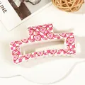 Macro view of a large pink checkered hair claw clip with heart patterns and glossy finish - 8.5cm Heart Print - Style H White Base