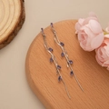 Detail view of long silver tassel earrings with purple marquise cut stones on wood base - Silver - Purple Zirconia