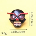 Detail shot of a black and red ghost resin accessory showing 3.3cm width and 5.6g weight - Red Face Skeleton