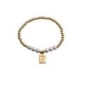 Close-up of gold beads and white pearls bracelet with a rectangular letter P charm - Letter P