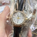 DOUKOU Women Quartz Watch with gold rhinestone case and black leather strap in hand - Black