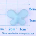 Glitter light blue butterfly resin accessory for DIY crafts on a measurement grid - Blue
