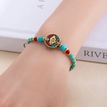Détail d'un bracelet de perles bohème avec perles turquoise et pendentif totem vintage - Bonne Chance Constante