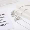 Polished silver hollow teardrop pendant necklaces with sleek snake chains on white background - Silver