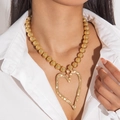 Close-up of golden faux pearl necklace featuring a large hollow heart-shaped pendant - Gold (Gold Bead Chain Heart Pendant)