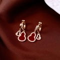 Detalle macro de pendientes de calabaza en oro de 14K con circonitas brillantes y diseño calado - Hebilla de Oreja - Dorado - Rojo - Chapado en Oro Real