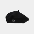 Close-up of black wool beret with white crown embroidery on a grey background - Black