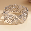 Detailed macro of silver hollow flower bracelet with intricate metal textures and clasp - Silver