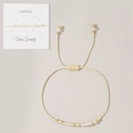 Adjustable woven rope bracelet with clear quartz beads and golden copper accents - April-Clear Quartz (Card Pack)