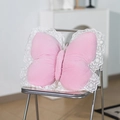 Roze pluche vlinderkussen met witte kant op een zilveren stoel bij de wand - Roze