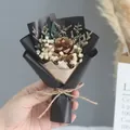 Detailed shot of a mini bouquet featuring a pine cone, baby's breath, and eucalyptus leaf - Pine Cone Gypsophila (Black Wrapping)