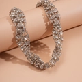Luxurious silver twist chain necklace with shimmering rhinestones on a cylindrical stand - Silver