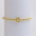 Polished golden beaded bracelet featuring a 3D letter H pendant on a display stand - Gold H