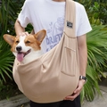Outdoor crossbody pet carrier in khaki cotton showing a corgi dog being carried by a model - Khaki