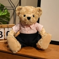 Teddybär Plüschtier mit rosa gestreiftem Hemd und schwarzer Hose auf Holztisch - Rosa gestreifter Anzug - Männlich