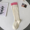 Chaussettes montantes en maille blanc crème avec revers contrastés roses sur table blanche - Poignet Rose Vif
