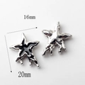 Detail of 20mm irregular star charms with liquid metal melt effect and black enamel finish - Star Bead