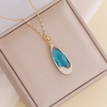 Collana dorata con ciondolo a goccia blu, piccoli diamanti e dettaglio a forma di cuore - Blu lago