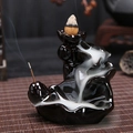Ceramic backflow incense burner in black with lotus leaf design and flowing smoke - Rising Step by Step